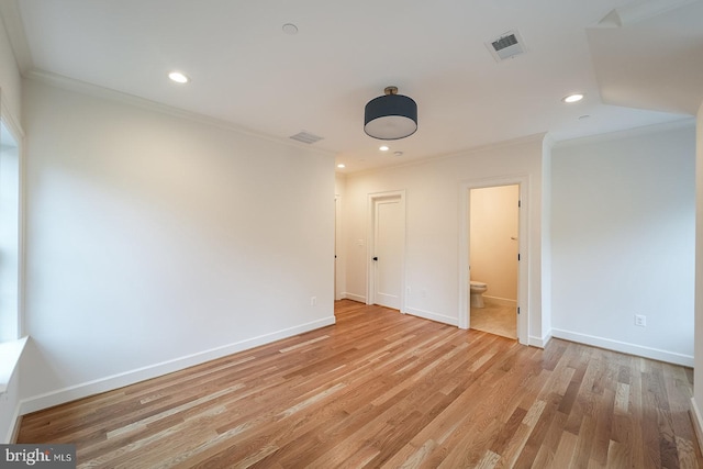 spare room featuring light hardwood / wood-style flooring and crown molding