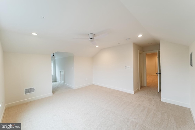 empty room featuring ceiling fan, light colored carpet, and lofted ceiling