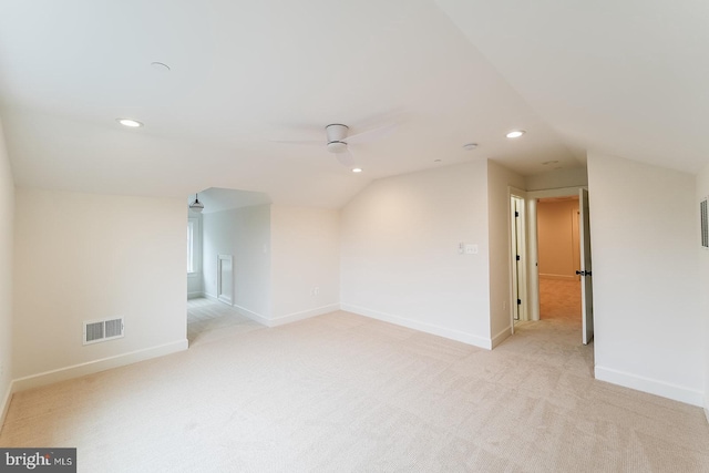 unfurnished room featuring ceiling fan, light colored carpet, and vaulted ceiling