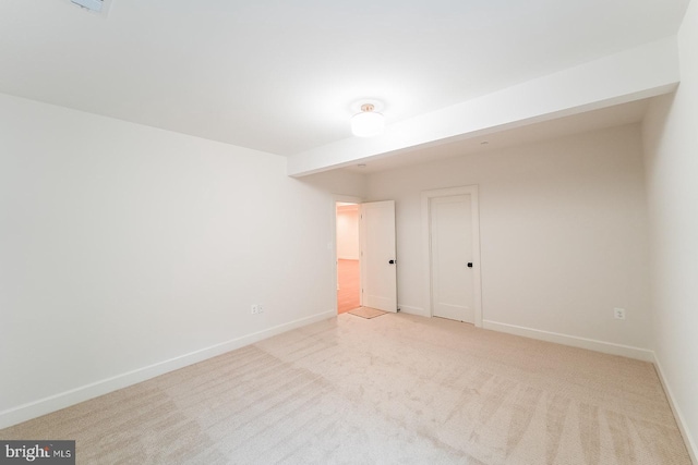 unfurnished room featuring light colored carpet