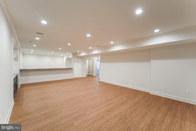 basement with ornamental molding and light wood-type flooring