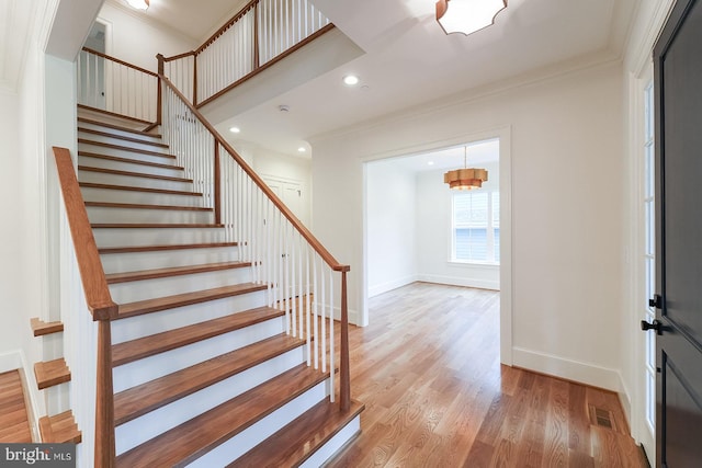 entryway featuring ornamental molding and light hardwood / wood-style flooring