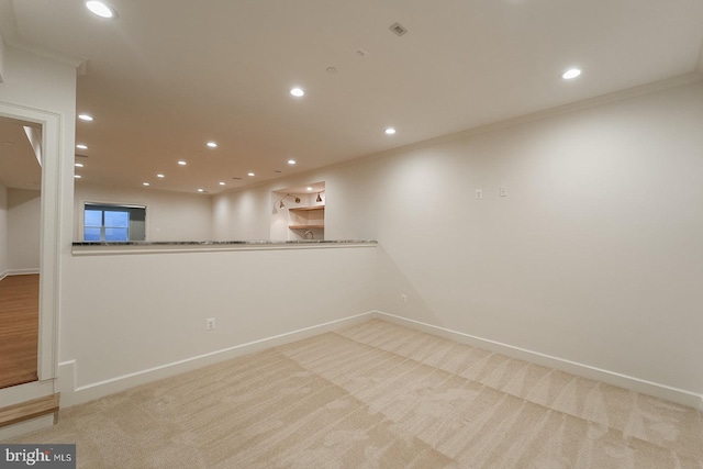 spare room featuring crown molding and light colored carpet