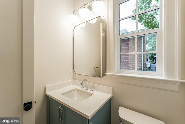 bathroom featuring plenty of natural light, vanity, and toilet