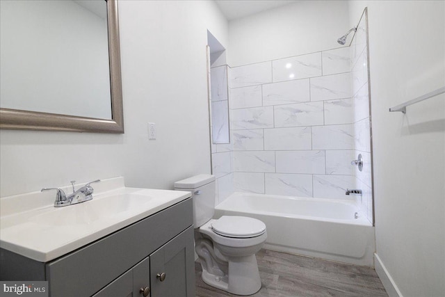 full bathroom with hardwood / wood-style floors, vanity, toilet, and tiled shower / bath combo