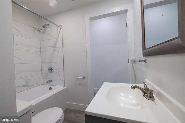 full bathroom featuring hardwood / wood-style floors, vanity, toilet, and tiled shower / bath combo