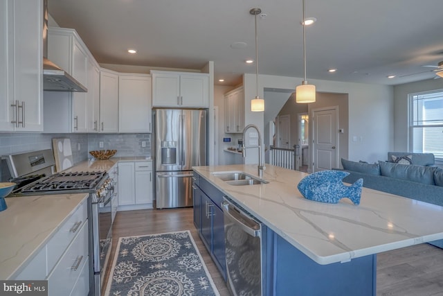 kitchen featuring white cabinetry, stainless steel appliances, and an island with sink