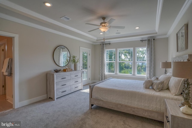 bedroom with light carpet, ornamental molding, a tray ceiling, and ceiling fan