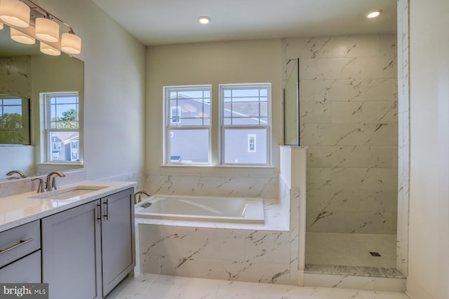 bathroom featuring vanity, independent shower and bath, and a wealth of natural light