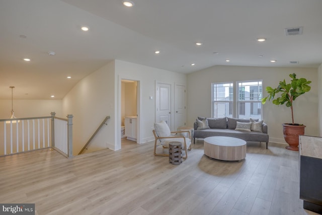 living room featuring vaulted ceiling and light hardwood / wood-style flooring