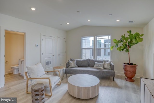 living room featuring vaulted ceiling and light hardwood / wood-style floors