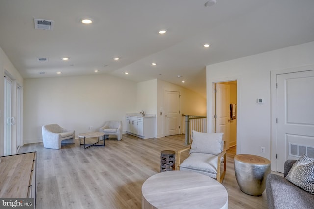 sitting room featuring vaulted ceiling and light wood-type flooring