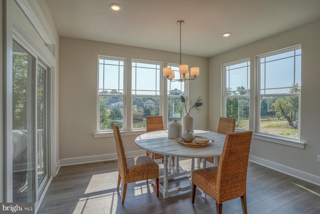 dining space with an inviting chandelier, dark hardwood / wood-style floors, and a healthy amount of sunlight