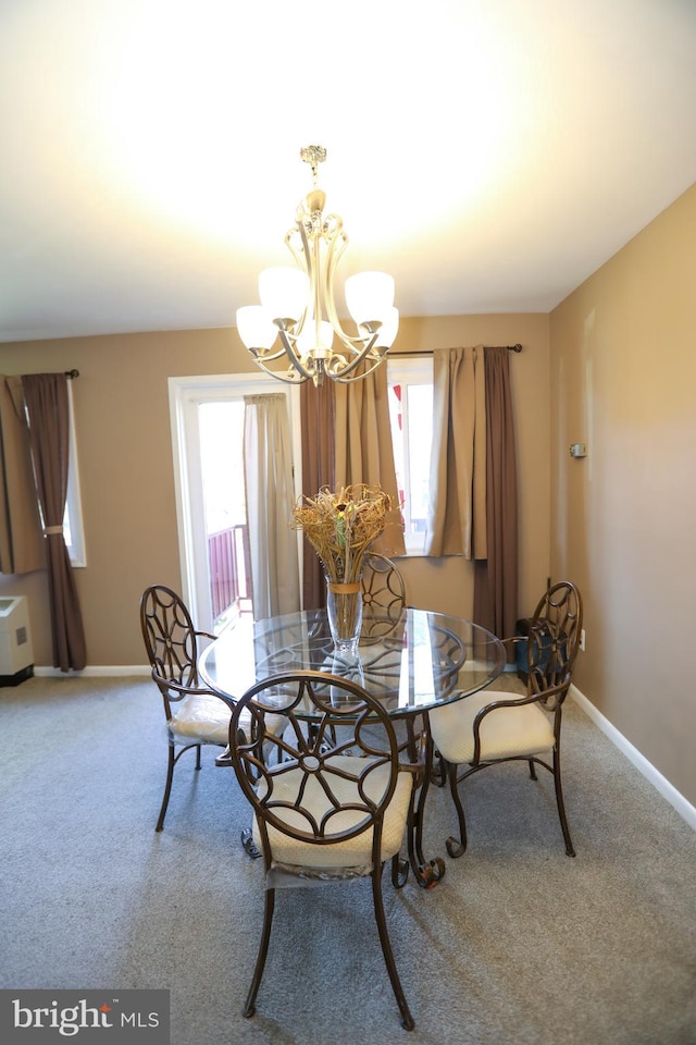 carpeted dining space featuring a notable chandelier