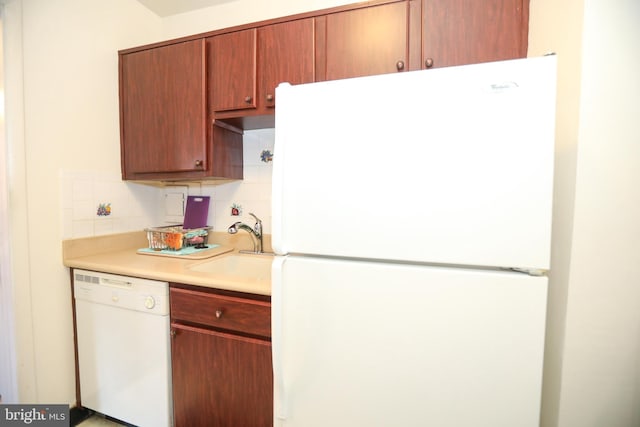 kitchen with light countertops, white appliances, backsplash, and a sink