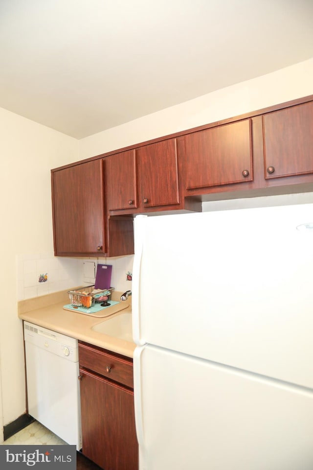 kitchen with light hardwood / wood-style flooring, backsplash, and white appliances