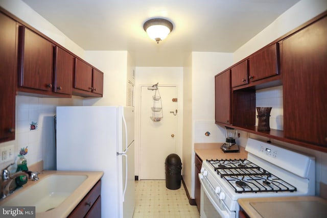 kitchen featuring light floors, white appliances, light countertops, and a sink