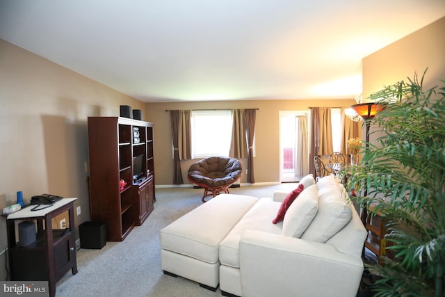 living area with light colored carpet and baseboards