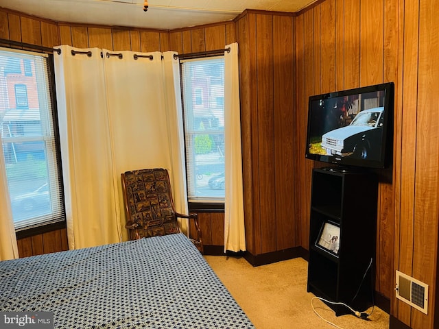 carpeted bedroom featuring wood walls