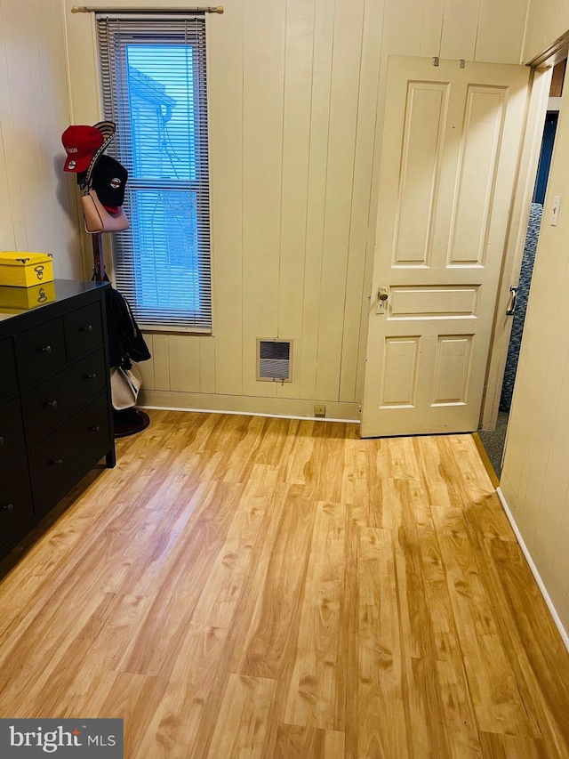 interior space with wood walls and light wood-type flooring