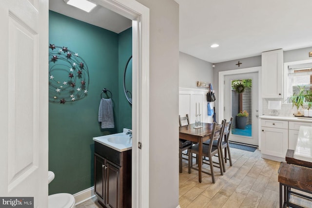 bathroom with vanity, backsplash, and toilet