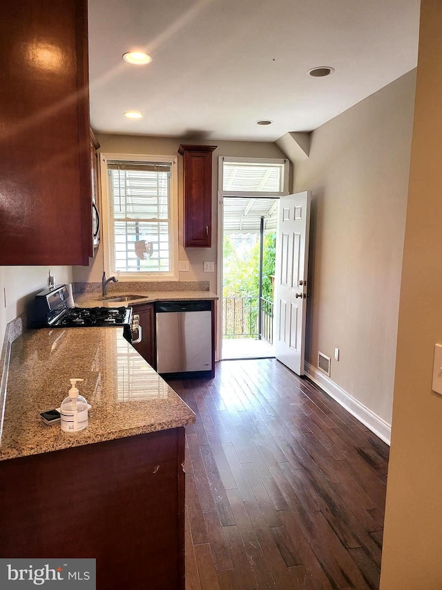 kitchen featuring sink, dark wood-type flooring, light stone countertops, and appliances with stainless steel finishes