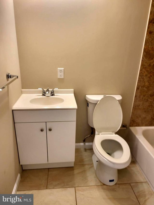 bathroom with tile patterned flooring, vanity, a bathtub, and toilet