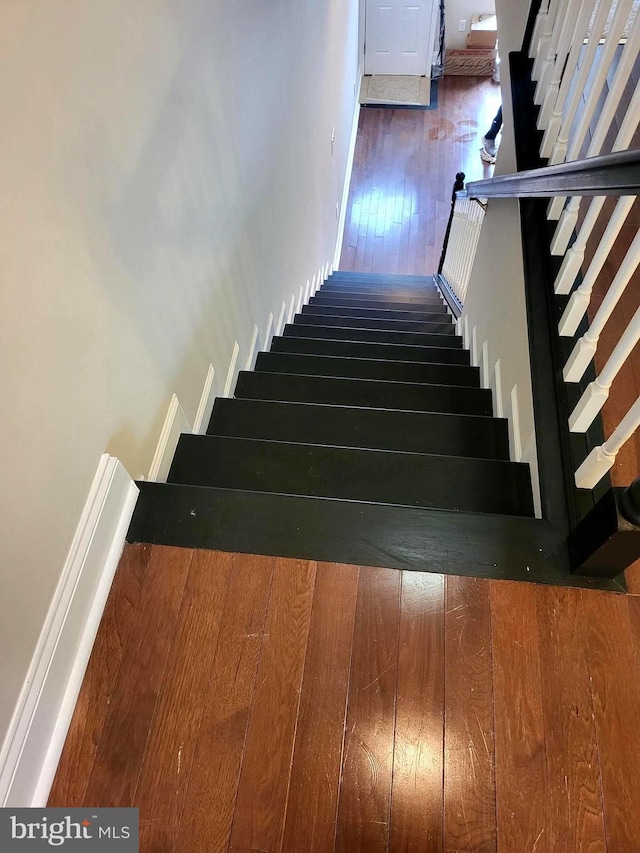 stairway featuring wood-type flooring