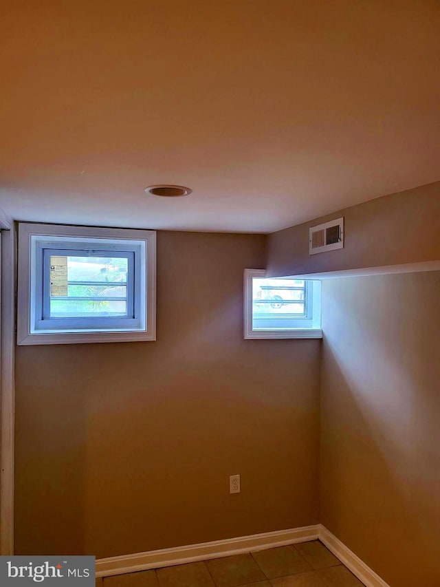 basement with plenty of natural light and tile patterned flooring