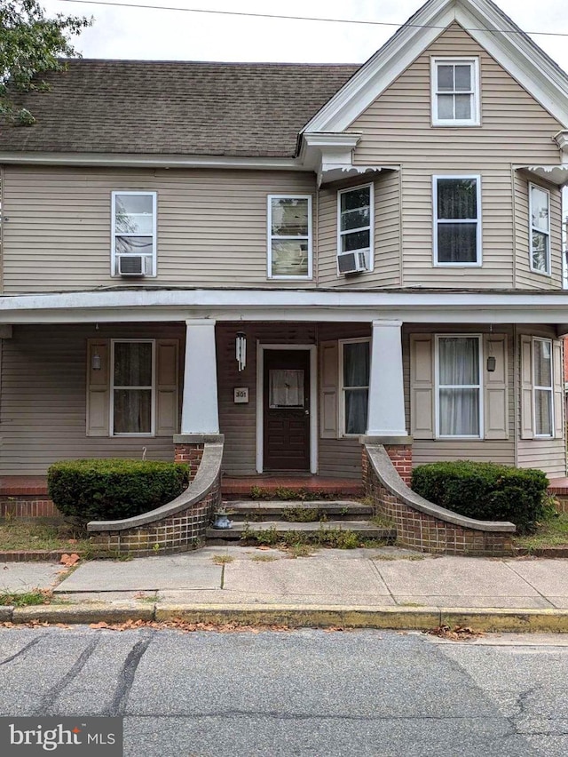 townhome / multi-family property featuring roof with shingles and covered porch