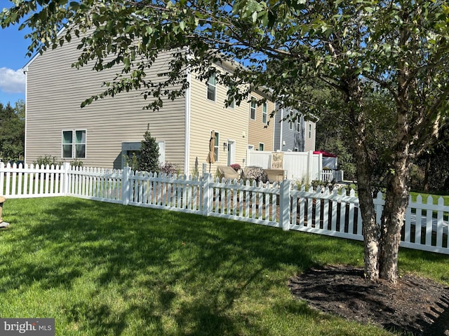 view of side of home with a deck, a yard, and central AC