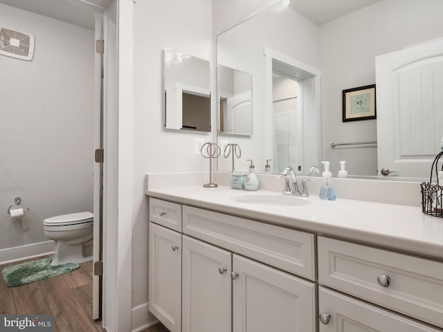 bathroom featuring vanity, hardwood / wood-style floors, and toilet