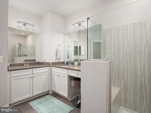 bathroom featuring vanity, tile patterned flooring, and tiled shower