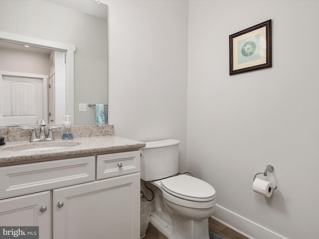 bathroom with vanity, toilet, and hardwood / wood-style flooring