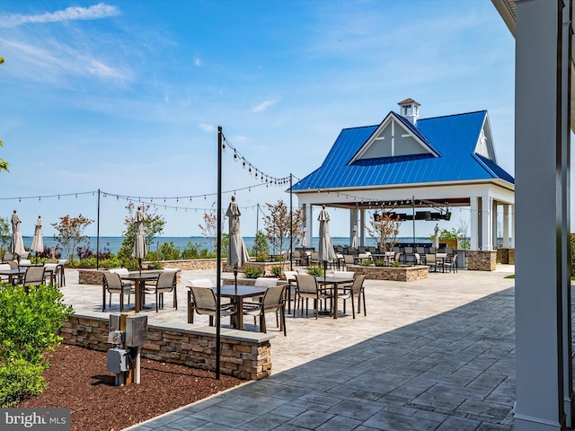 view of community with a water view, a gazebo, and a patio