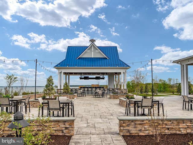 view of home's community with a gazebo, a water view, and a patio area