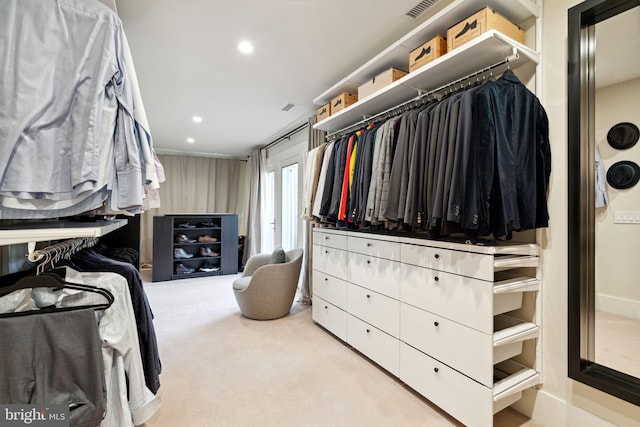 walk in closet with light colored carpet