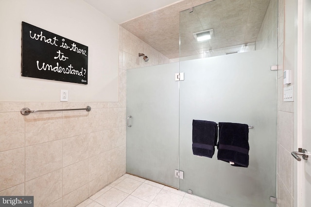 bathroom featuring tile walls, tile patterned flooring, and a shower with door