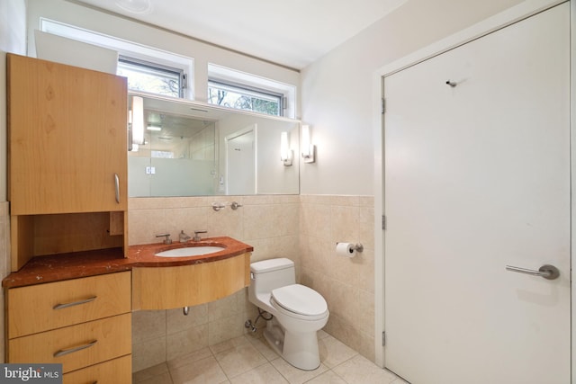 bathroom with tile walls, tile patterned flooring, vanity, and toilet