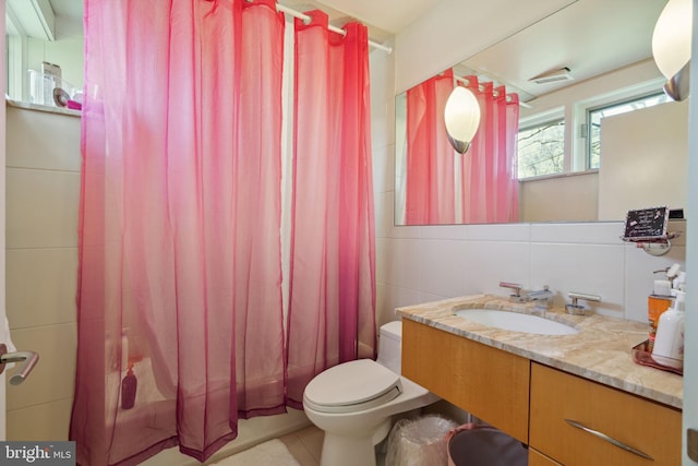 bathroom featuring tile walls, backsplash, vanity, toilet, and tile patterned floors