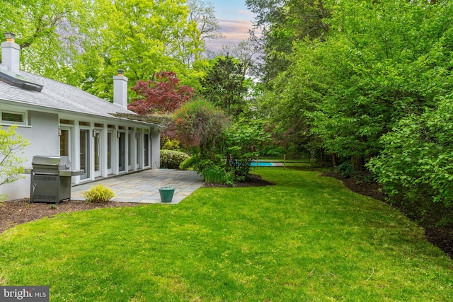 yard at dusk featuring a patio