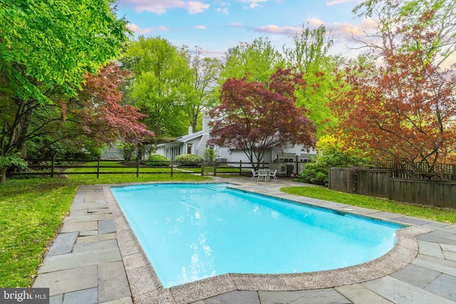 view of pool featuring a lawn and a patio area