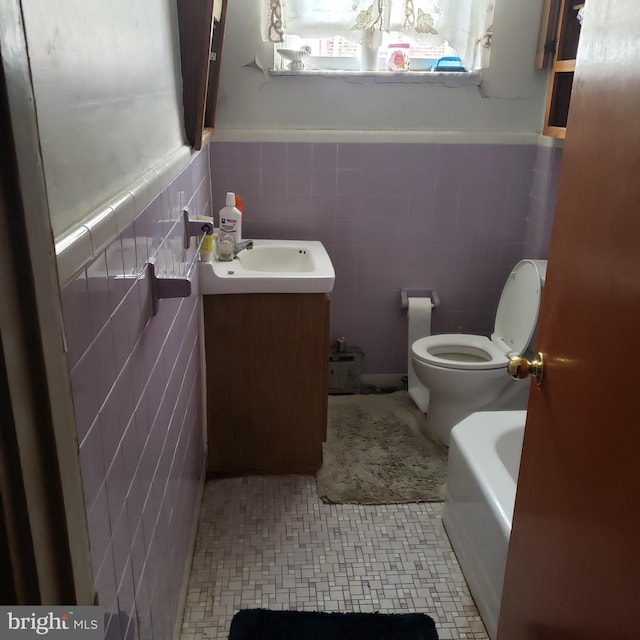 bathroom featuring tile walls, vanity, and toilet