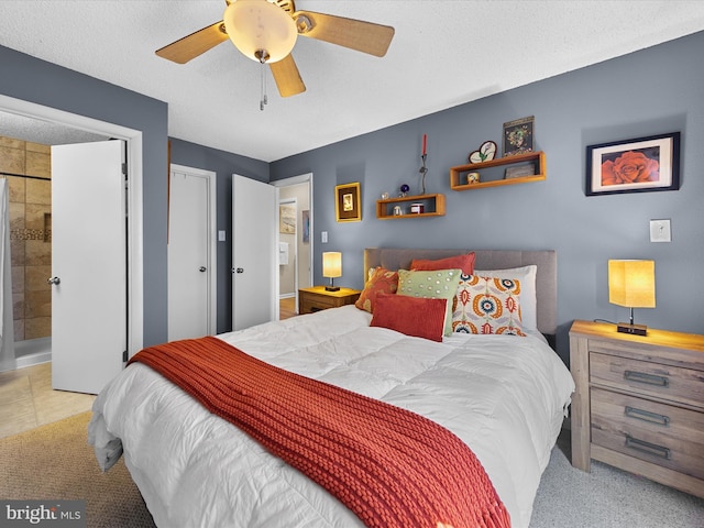 carpeted bedroom featuring ceiling fan, connected bathroom, and a textured ceiling