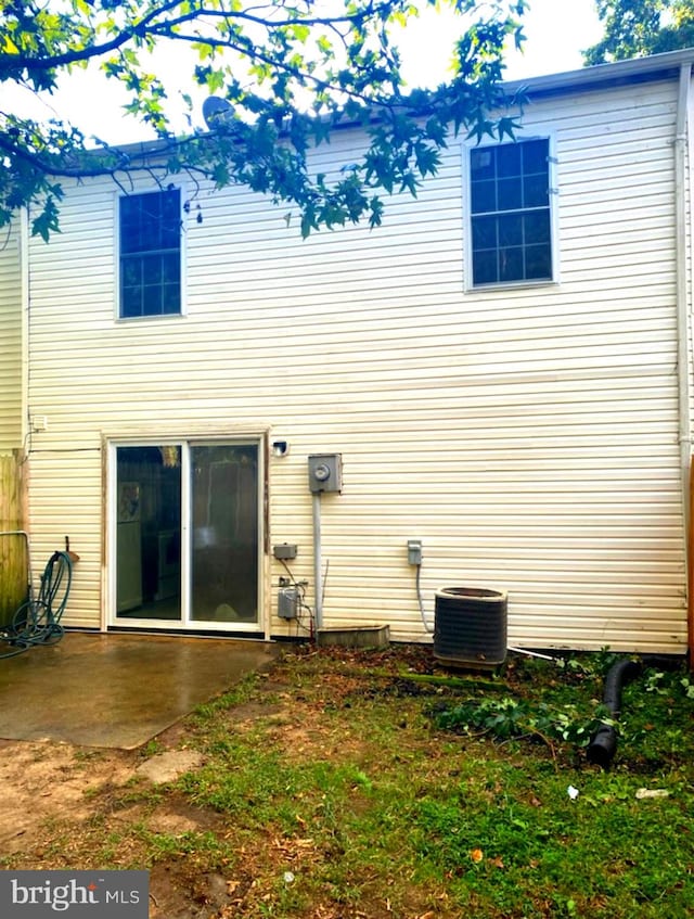 rear view of property with cooling unit and a patio area