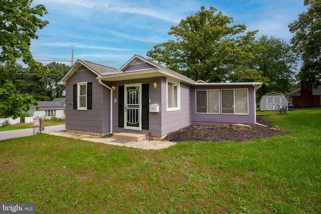 view of front facade with a storage shed and a front lawn