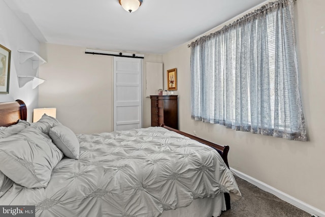 carpeted bedroom featuring a barn door