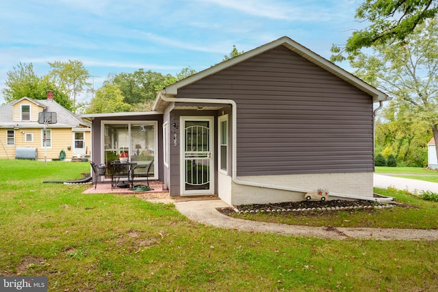 back of property featuring a patio area and a yard