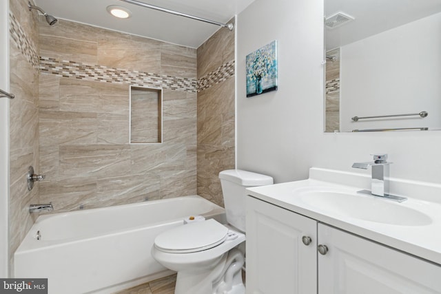 full bathroom featuring vanity, tiled shower / bath combo, and toilet