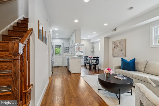 living room with light hardwood / wood-style floors and sink